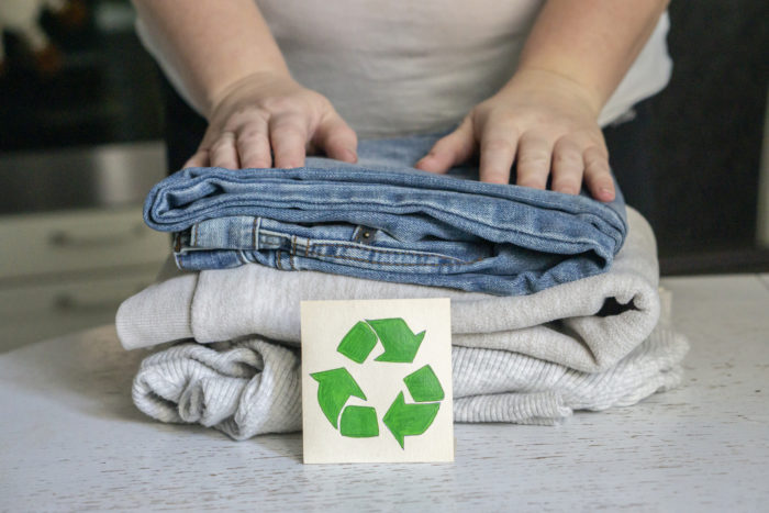 Garment recycling concept. A stack of clothes is on the recycling table. Collection of clothes for recycling